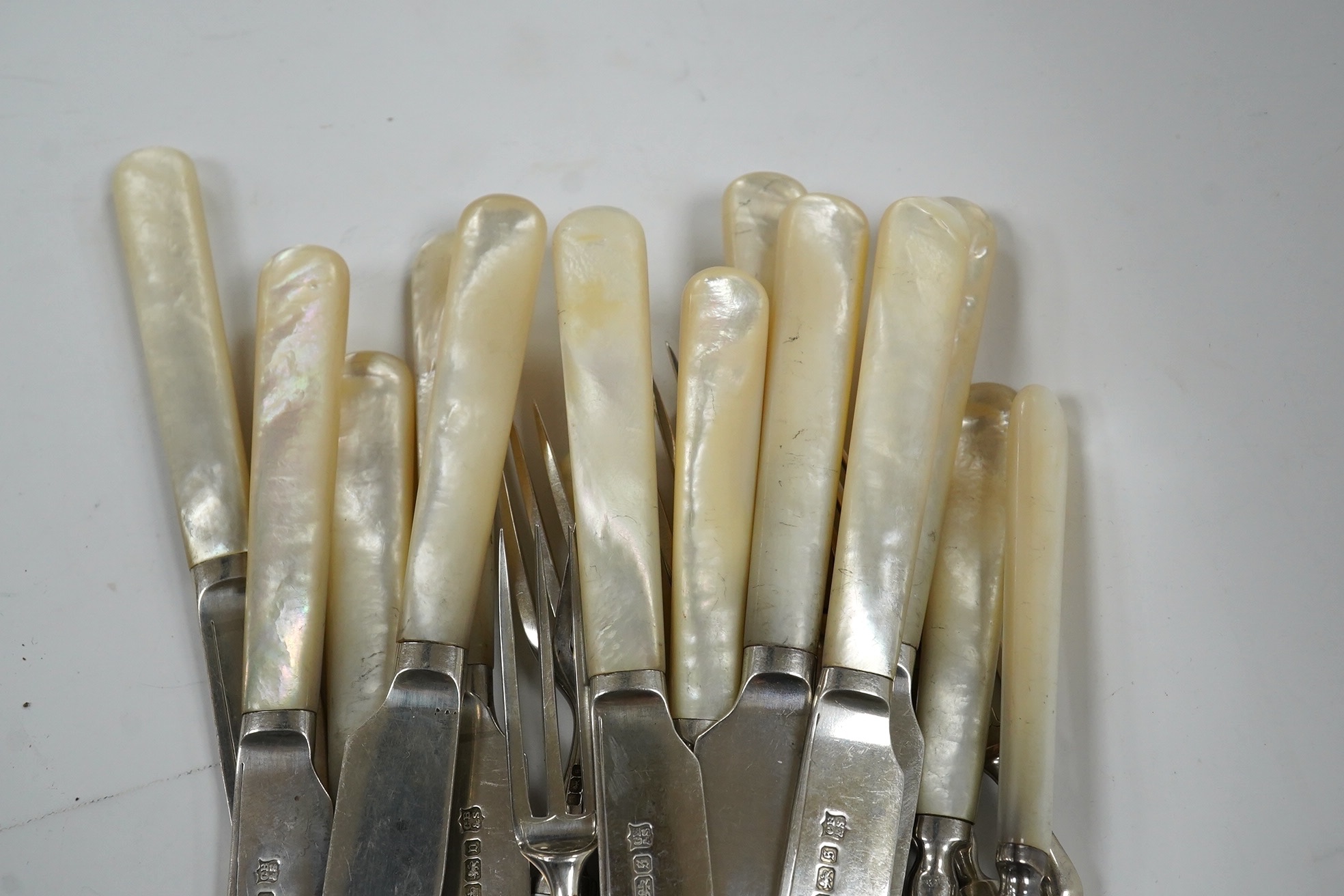 Ten George V mother of pearl handled silver dessert eaters and eleven matching forks, Cooper Brothers & Sons, Sheffield, 1910/13. Condition - fair